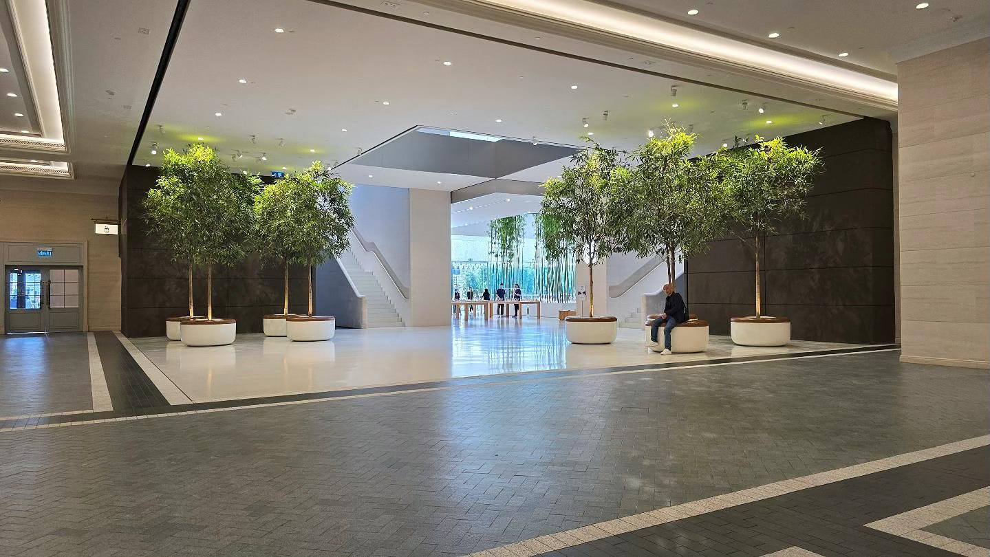 Trees with integrated seating line the mall entrance to Apple Cotai Strip.