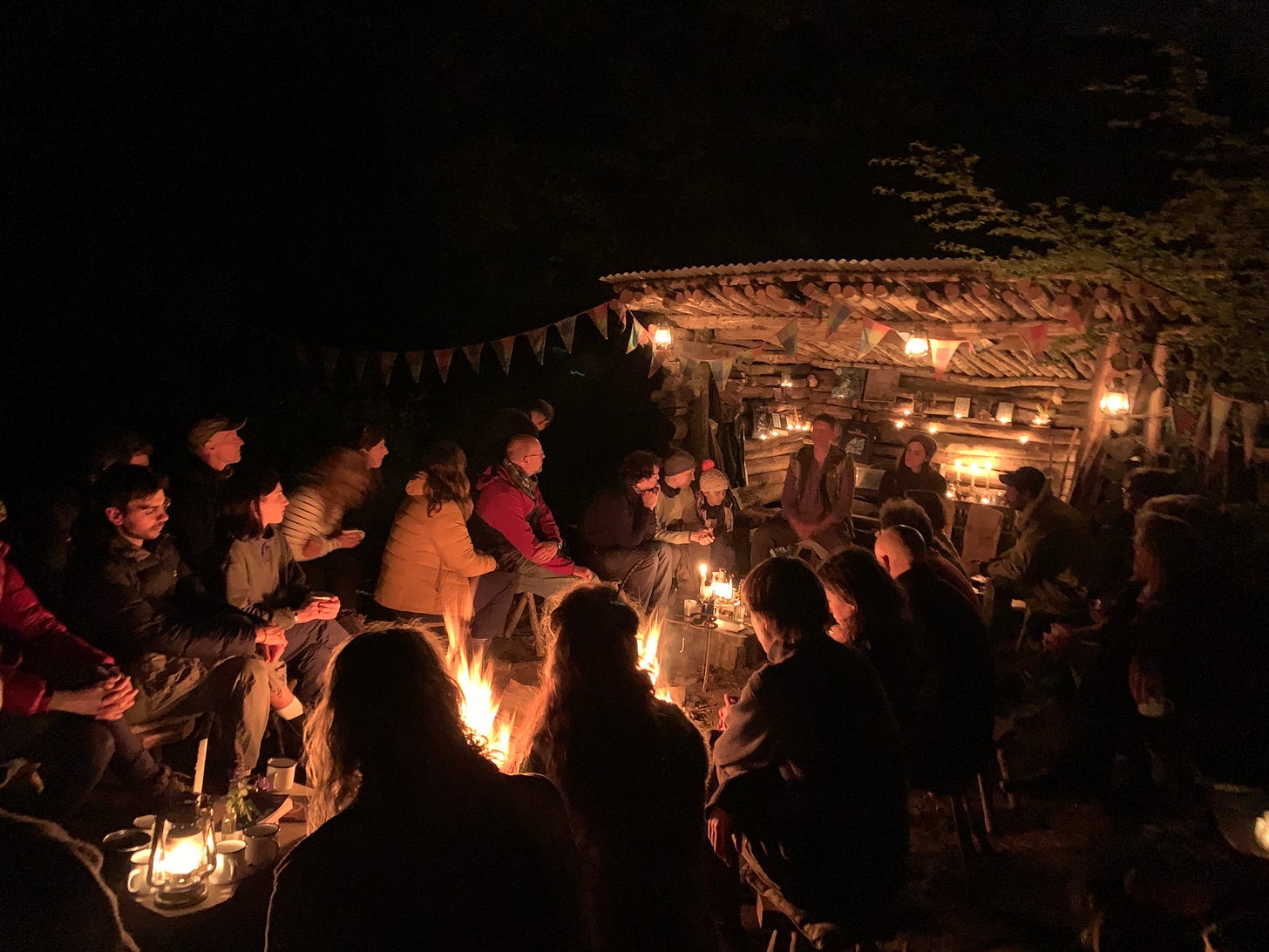 A group of people gathered around the fire in the dark