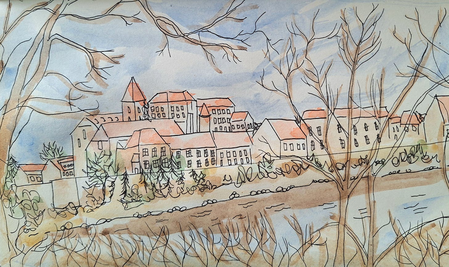 Pen and watercolour sketch of Ptuj, seen between trees over the river.  Ptuji is an old town with cream stone buildings and red roofs.