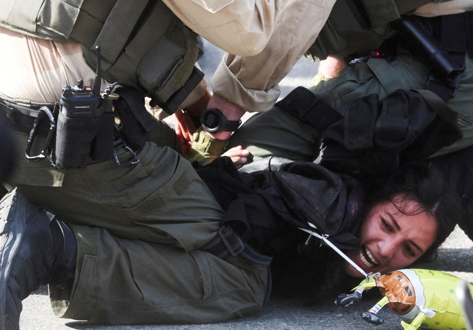 Law enforcement officers detaining a protestor.