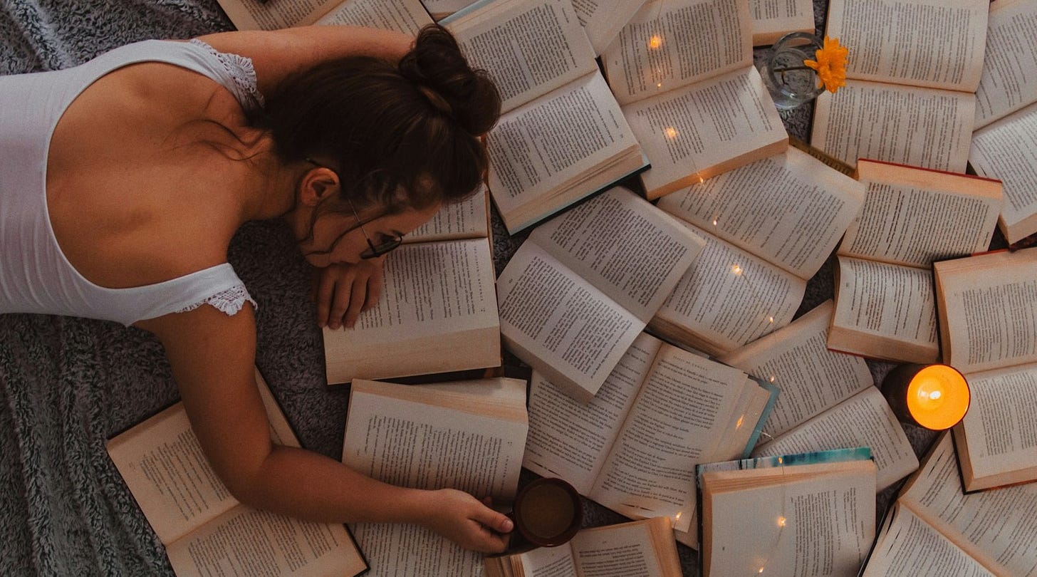 woman in white tank top reading book
