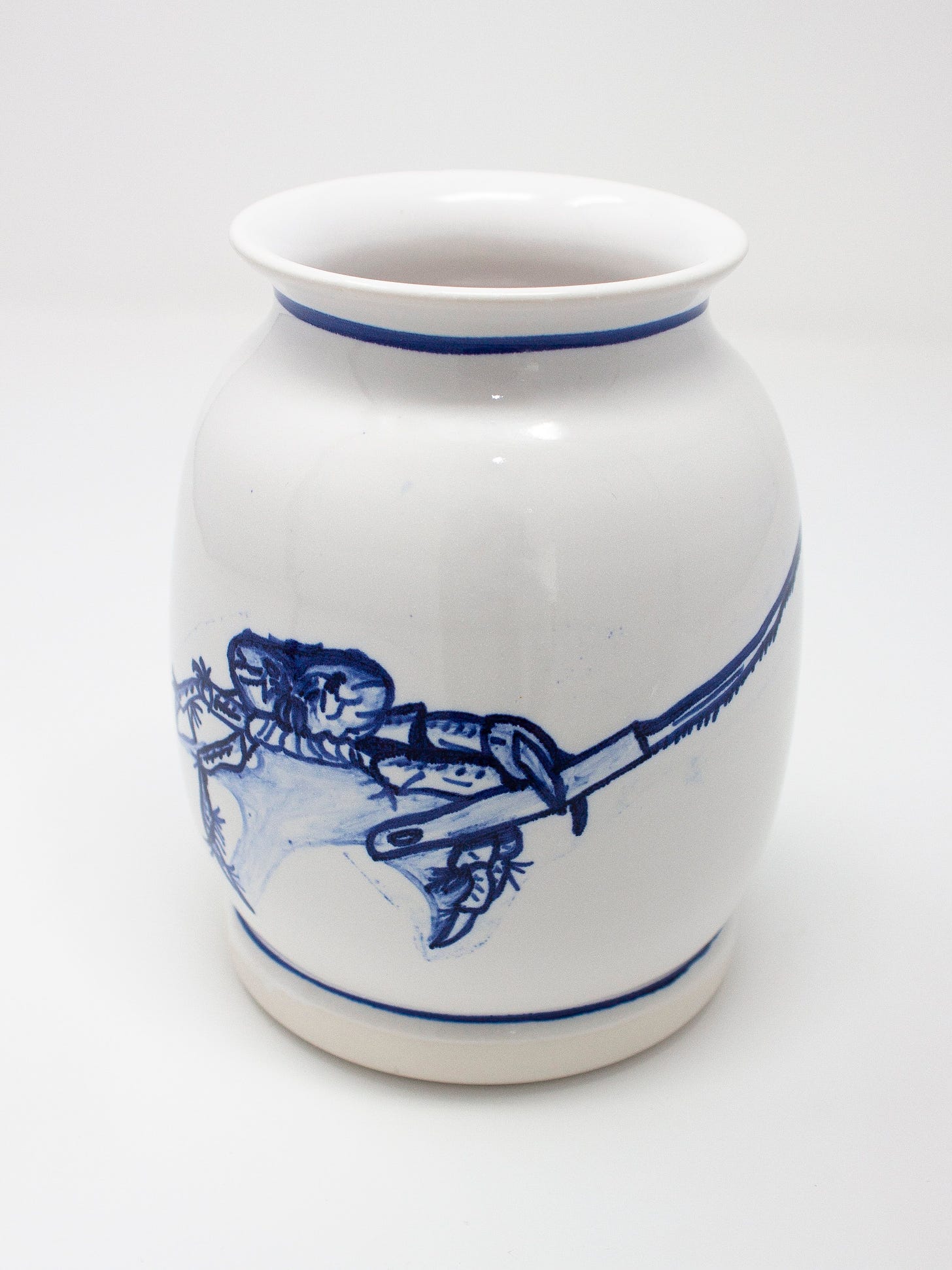 A beautiful white pottery vase with blue stripe details, and a blue painting of a crab holding a knife glazed onto it. 