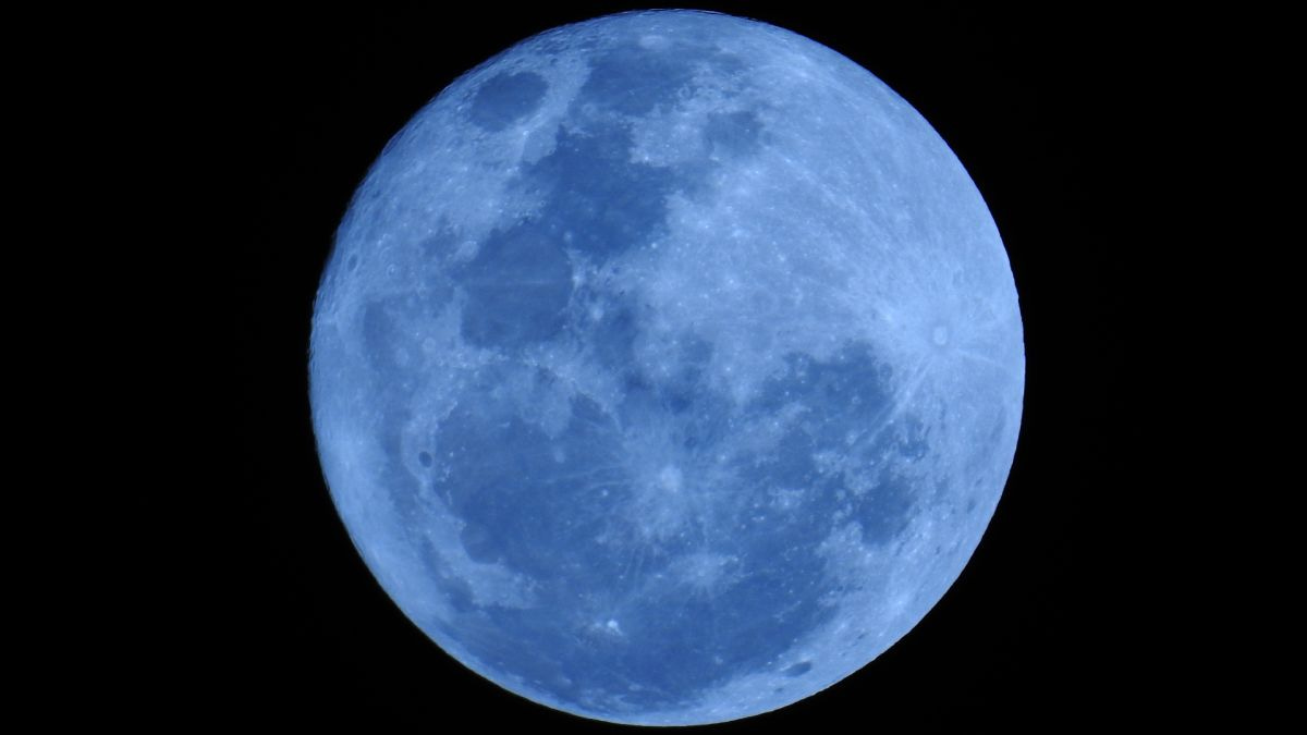 A photograph of the moon. The moon is tinted blue.