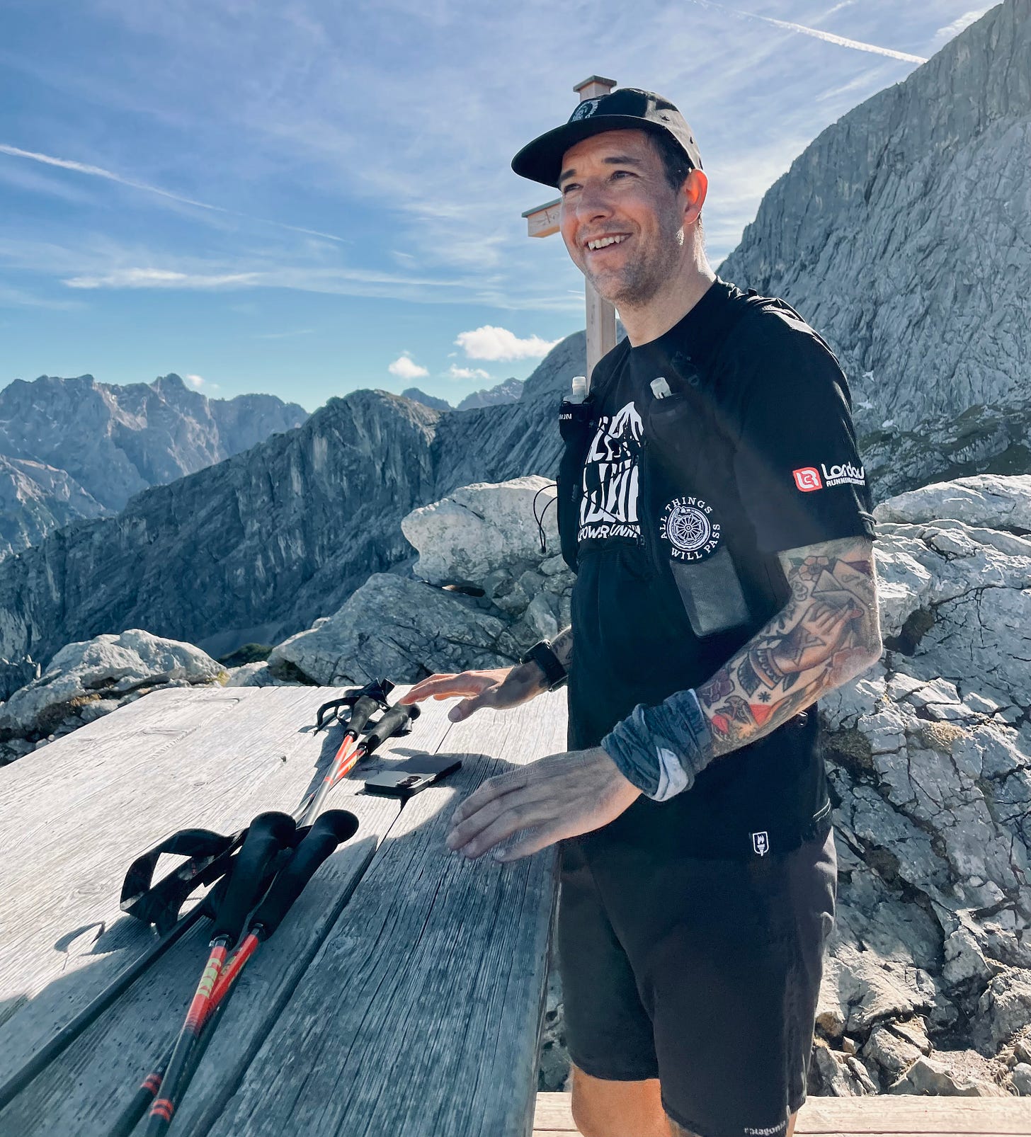 The author in trailrunning gear smiling in front of a mountain top