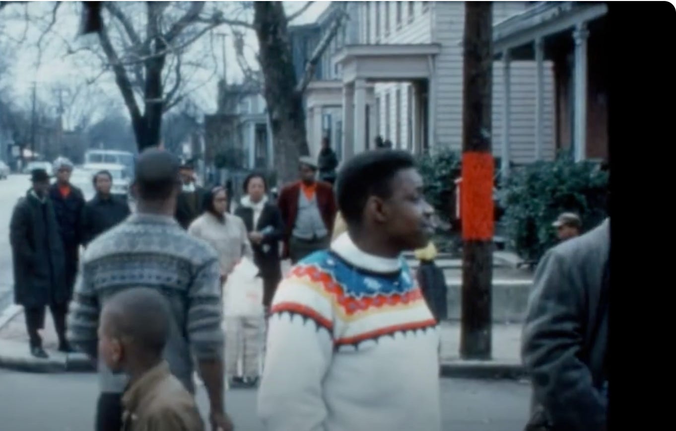 Street scene with people milling about wearing cold weather clothing. 