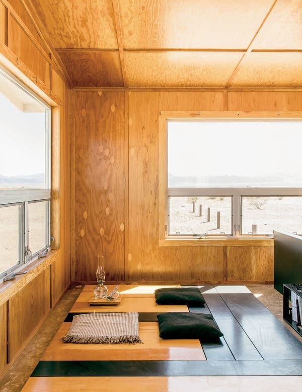 The interior of an “Experimental Living Cabin,” outfitted with a glass oil lantern and a “Planar Configuration” sculpture that is unadorned yet highly functional.