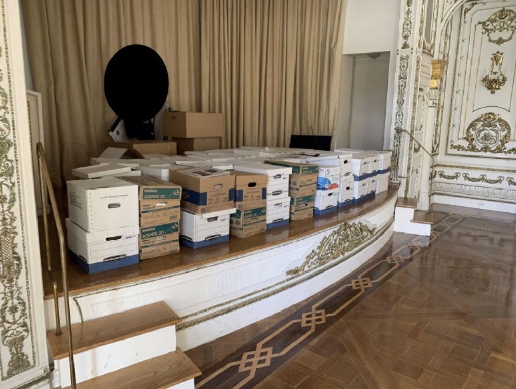 Photo of many boxes of classified documents stacked in an event room at Mar-a-Lago.
