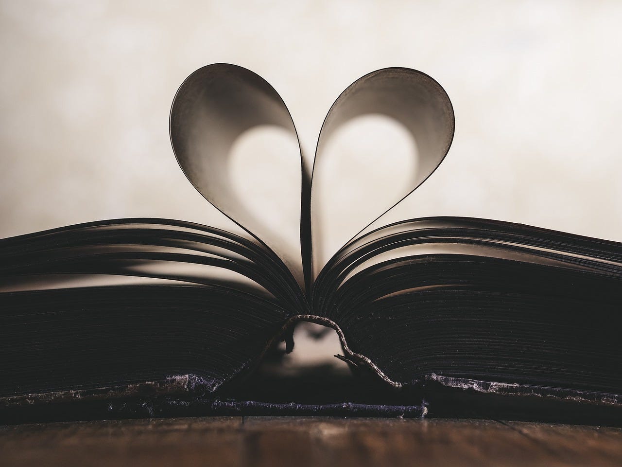 An open book with pages folded into a heart