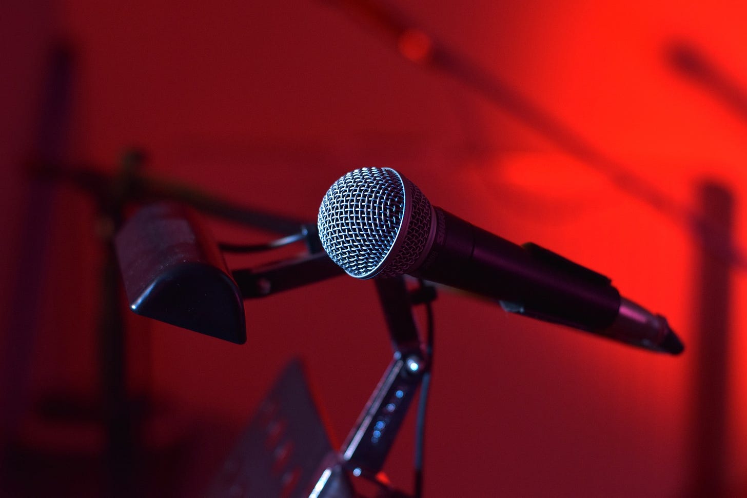 A microphone on a stand - red background