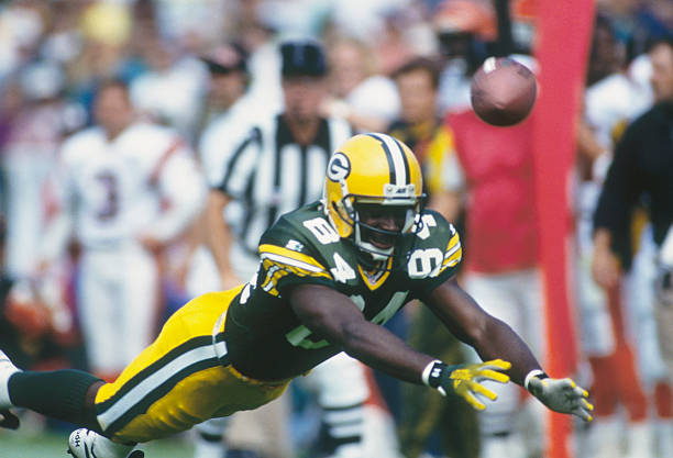 Green Bay Packers' Sterling Sharpe dives for the ball but misses the pass during a game.