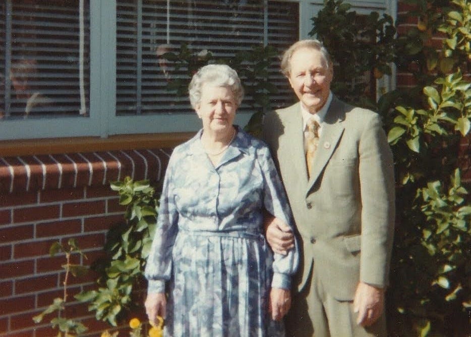 My grandparents Edith and Lance Blyth, dressed to the nines, in front of their brick house.