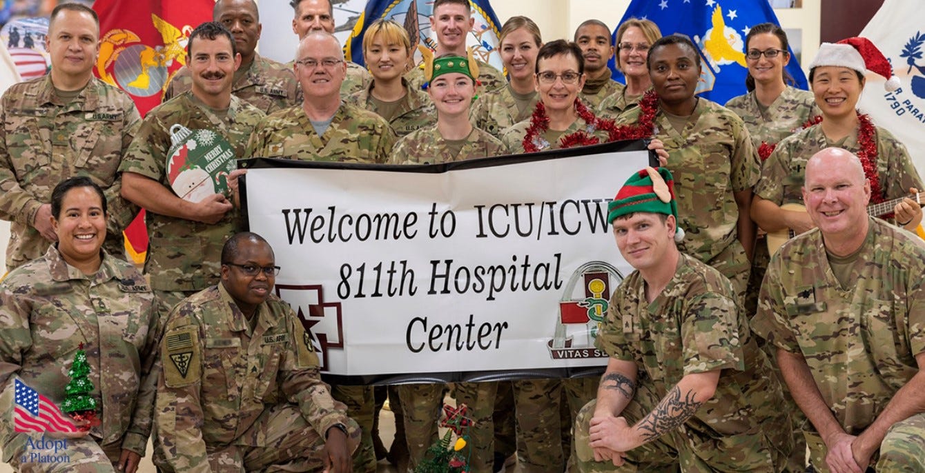 U.S. service personnel pose together as a group to thank Adopt a Platoon