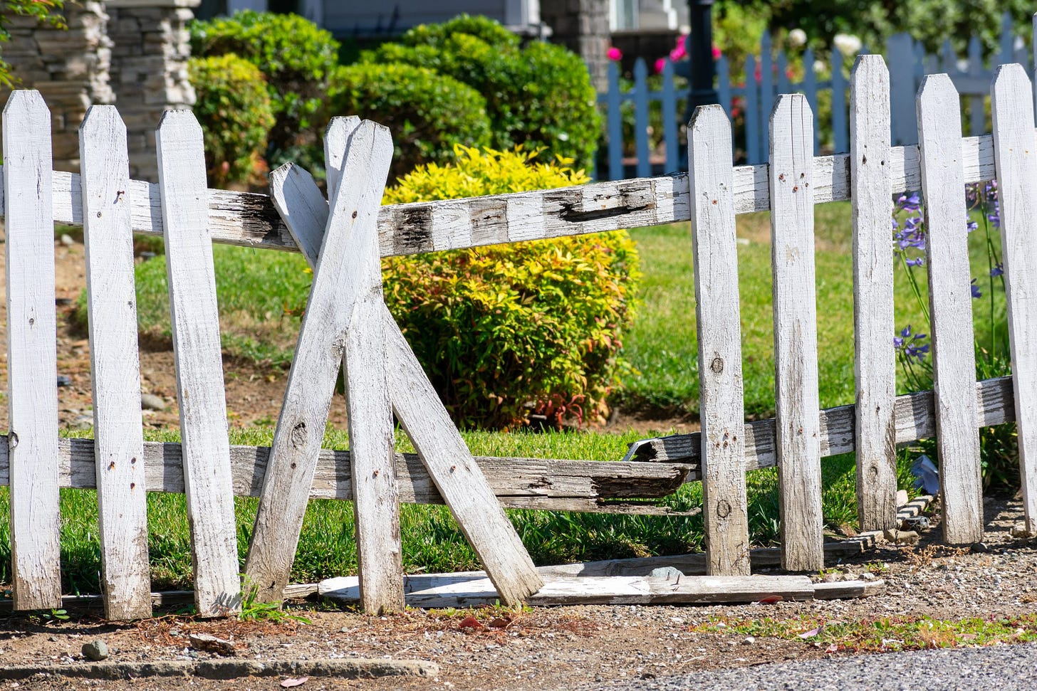 Broken,Fence.,Damaged,Weathered,White,Picket,Fence,With,Broken,Rails