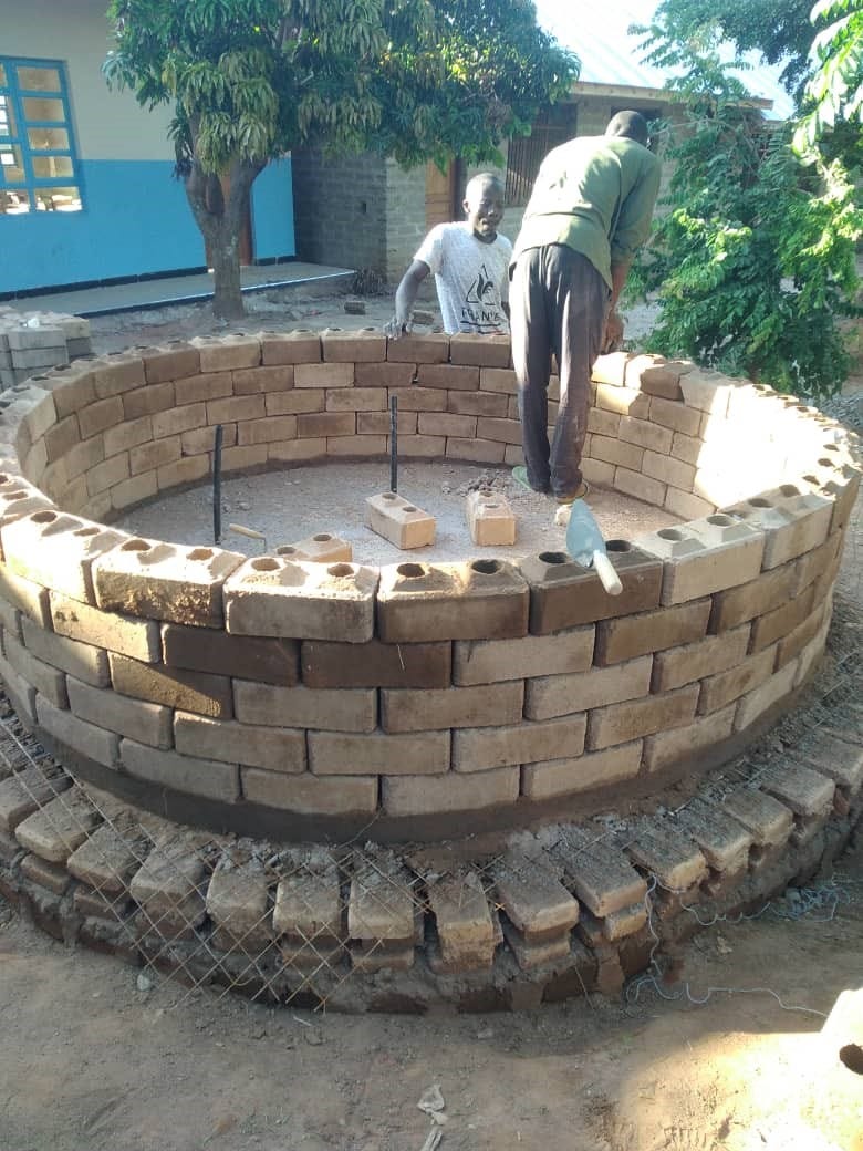 men constructing a water tank using interlocking bricks in Mwanza Tanzania