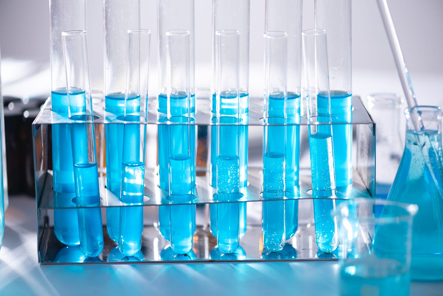 A row of beakers full of blue liquid