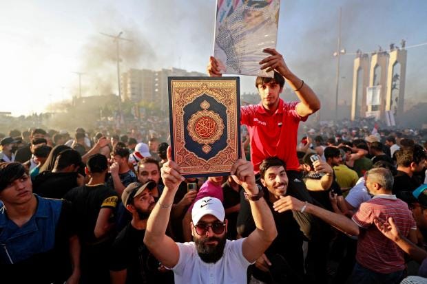 Irakilainen pitelee Koraanin kopiota Ruotsin suurlähetystön ulkopuolella Bagdadissa, Irakissa, 30. kesäkuuta 2023, toisena protestipäivänä Tukholman moskeijan ulkopuolella tapahtunutta Koraanin polttamista vastaan, joka närkästytti muslimeja ympäri maailmaa.