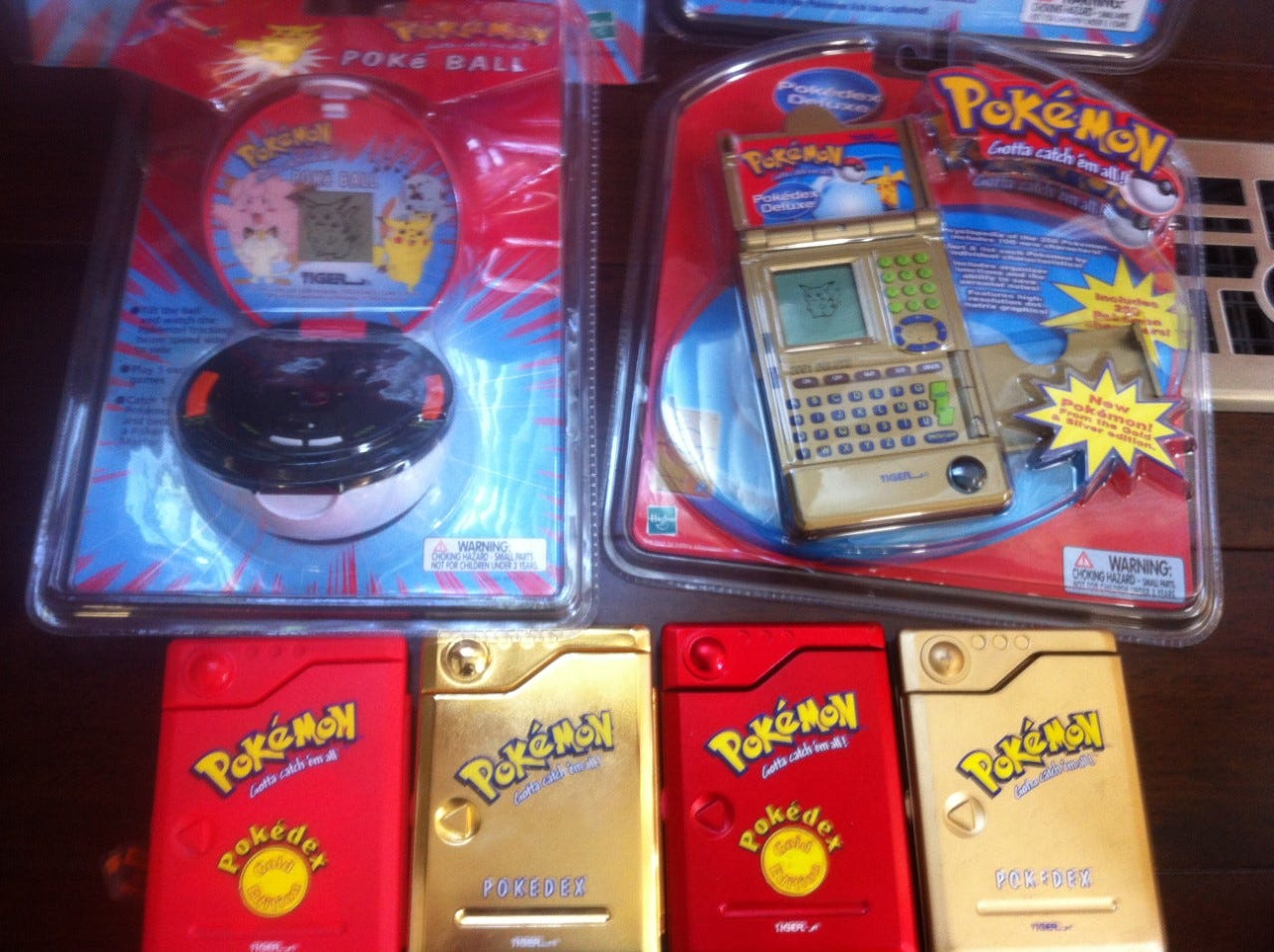 A picture of the “Gold Vac-Metal Pokedex”, an unreleased prototype of the original Pokédex. Also pictured are toys Chris worked on, including the Poké Ball, and the Pokédex Deluxe.