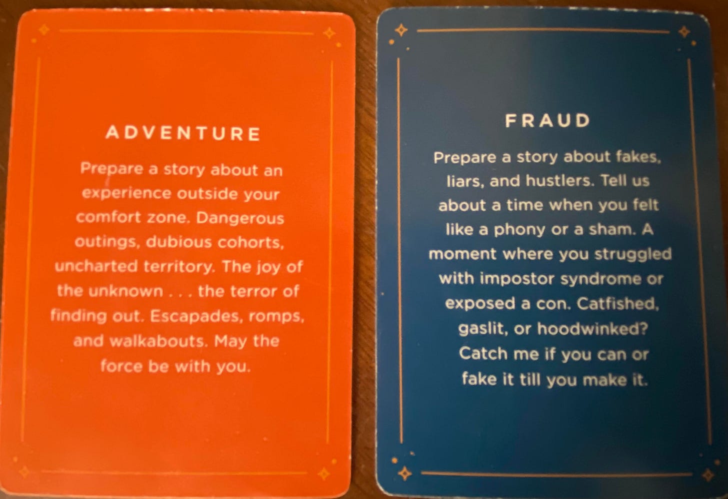 Photo of 2 cards drawn from The Moth Story Cards. Left card is titled "Adventure" and says below it: "Prepare a story about an experience outside your comfort zone. Dangerous outings, dubious cohorts, uncharted territory. The joy of the unknown...the terror of finding out. Escapades, romps, and walkabouts. May the force be with you." Second card on the right is titled: "Fraud" and says below it: "Prepare a story about fakes, liars, and hustlers. Tell us about a time when you felt like a phony or a sham. A moment where you struggled with imposter syndrome or exposed a con. Catfished, gaslit, or hoodwinked? Catch me if you can or fake it till you make it."