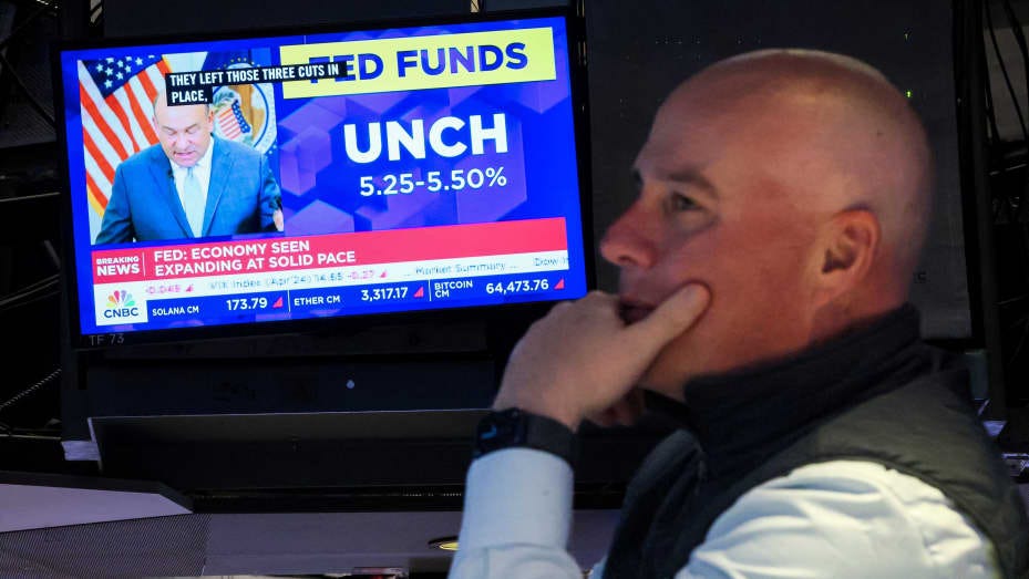 A trader works, as a screen displays the Fed rate announcement, on the floor of the New York Stock Exchange (NYSE) in New York City, U.S., March 20, 2024. REUTERS/Brendan McDermid