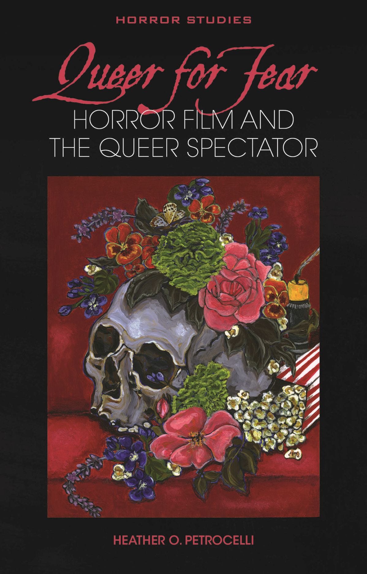 Black book cover that reads 'Horror Studies' across the top in all-caps above the title in hot-pink cursive font that reads 'Queer for Fear' above the white font subtitle: Horror film and the queer spectator'. The central image is a painting of a flower-crowned skull on a red velvet theatre seat next to a yellow snuffed-out candle and a spilled popcorn bucket. Below the painting image is the author's name: Heather O. Petrocelli