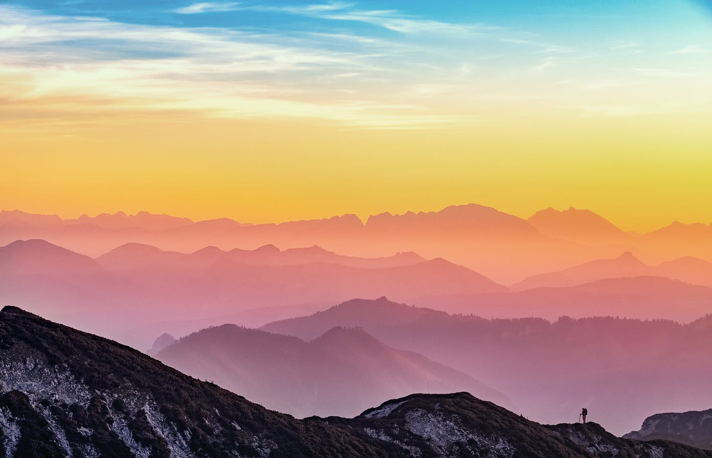 A photo of the sun setting over mountains. By Simon Berger from Unsplash.