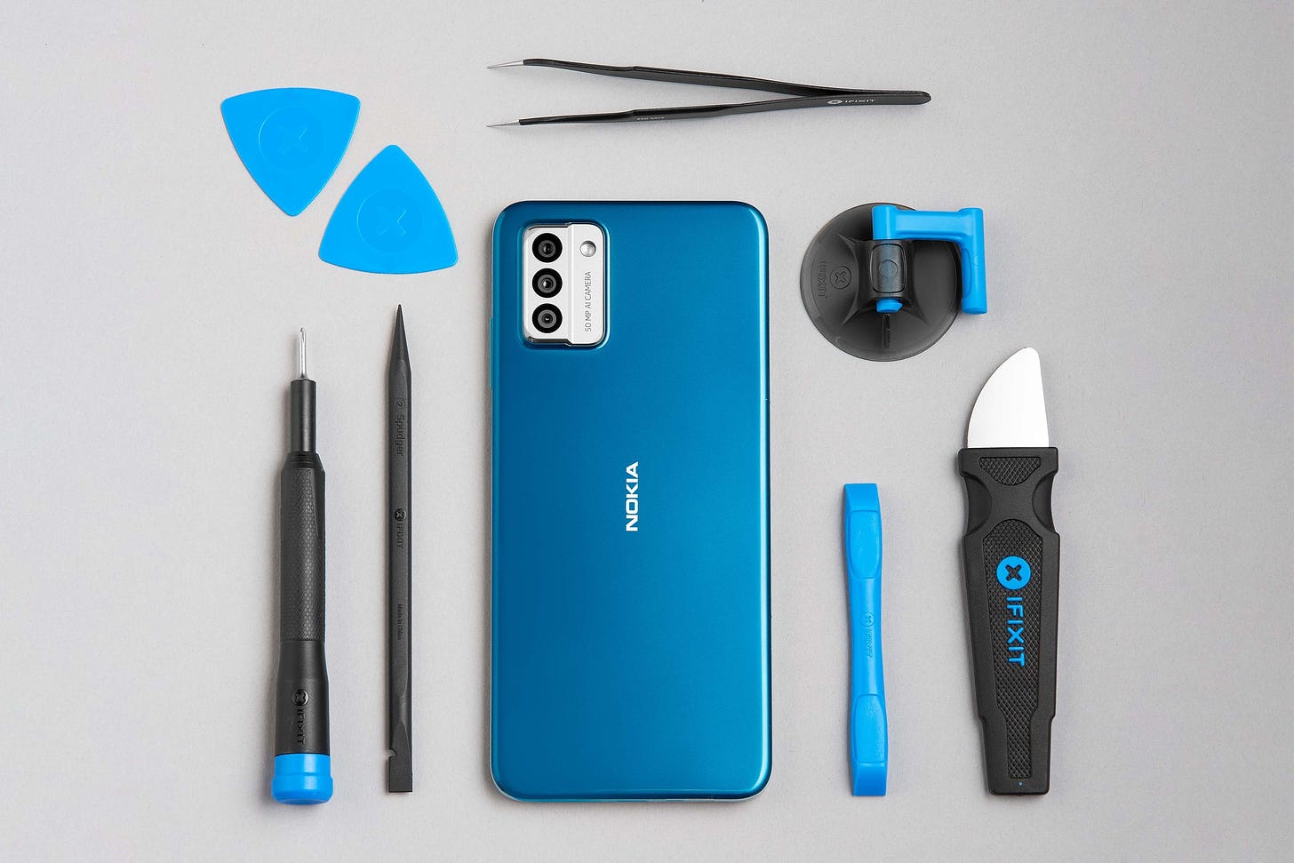 The Nokia G22 from the back, surrounded by iFixit repair tools.