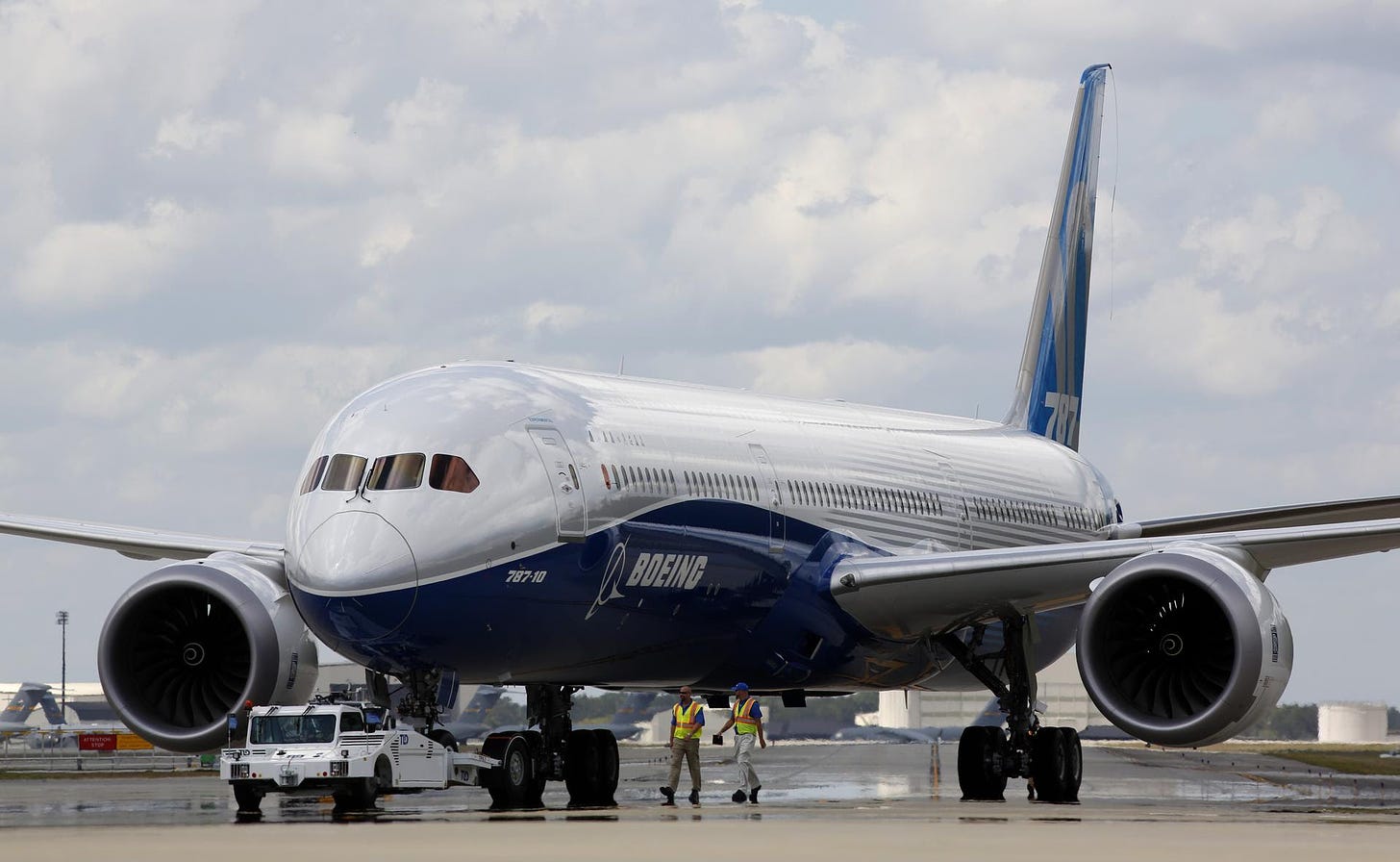 Employees walk a Boeing 787-10 Dreamliner towards a delivery ramp area.
