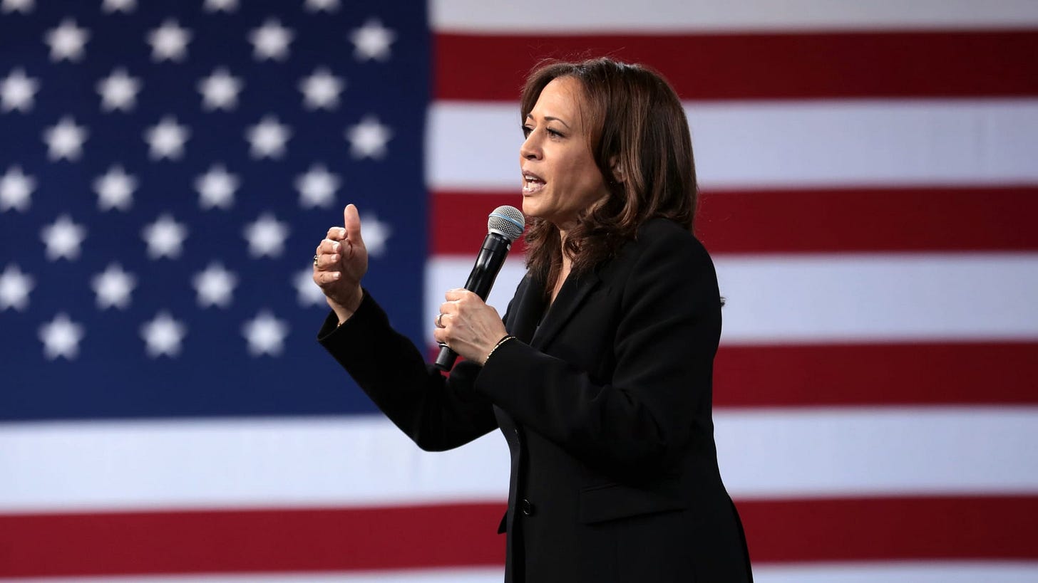 Kamala Harris speaking in front of a large US flag.