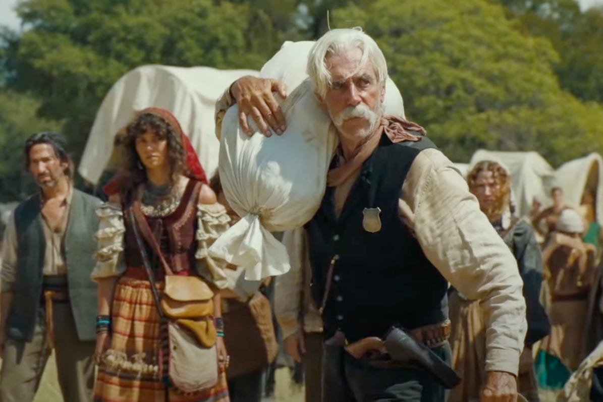 In the series “1883,” Shea Brennan (played by Sam Elliott) carries a large sack on his shoulder and returns oats or cornmeal to the settlers that had previously been stolen. He wears a worn shirt with a vest and neckerchief, a sheriff's badge on his chest, and a revolver on his belt. In the background are other settlers and covered wagons; the scene takes place in a makeshift camp under the open sky. In the series “1883,” Shea Brennan (played by Sam Elliott) carries a large sack on his shoulder and returns oats or cornmeal to the settlers that had previously been stolen. He wears a worn shirt with a vest and neckerchief, a sheriff's badge on his chest, and a revolver on his belt. In the background are other settlers and covered wagons; the scene takes place in a makeshift camp under the open sky.