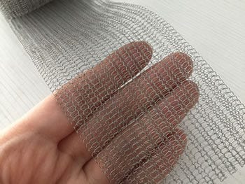 A piece of flattened knitted mesh in a woman’s hand.