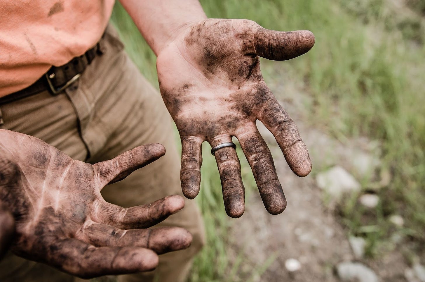 a photo of two hands covered in dirt or grease.