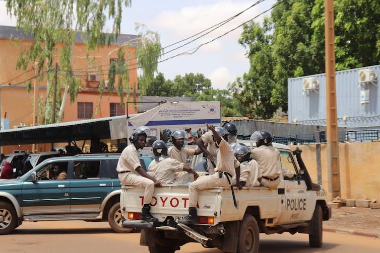 A group of police officers drive in a jeep through the streets of the capital Niamey.