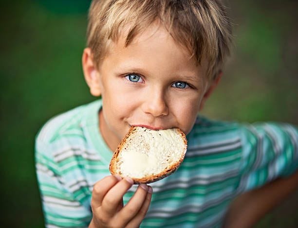 little boy eating loaf of bread with butter - bread and butter stock pictures, royalty-free photos & images