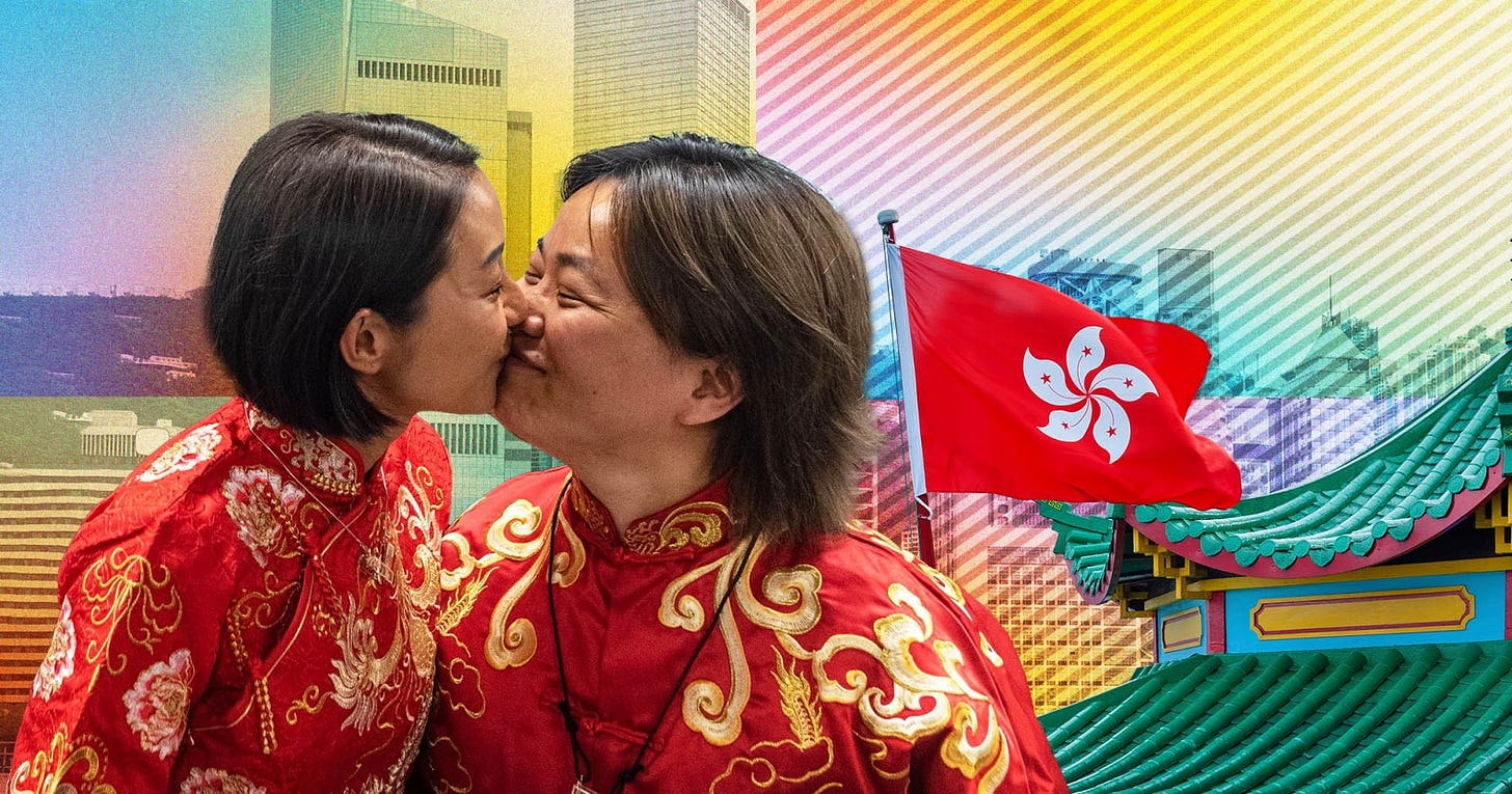 Two women kiss in front of a Hong Kong flag