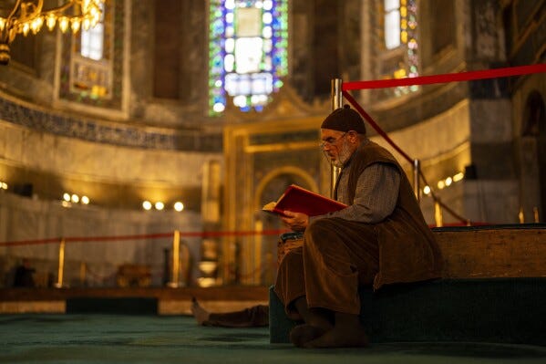 A Muslim worshipper reads the Quran, Islam's holiest book, during the Muslim holy fasting month of Ramadan at Hagia Sophia mosque in Istanbul, Turkey, Tuesday, March 12, 2024. (AP Photo/Francisco Seco)