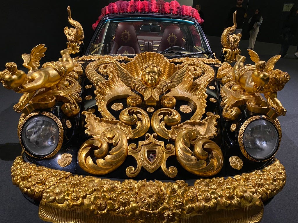 A porrche car with gilt cherubs and decoration