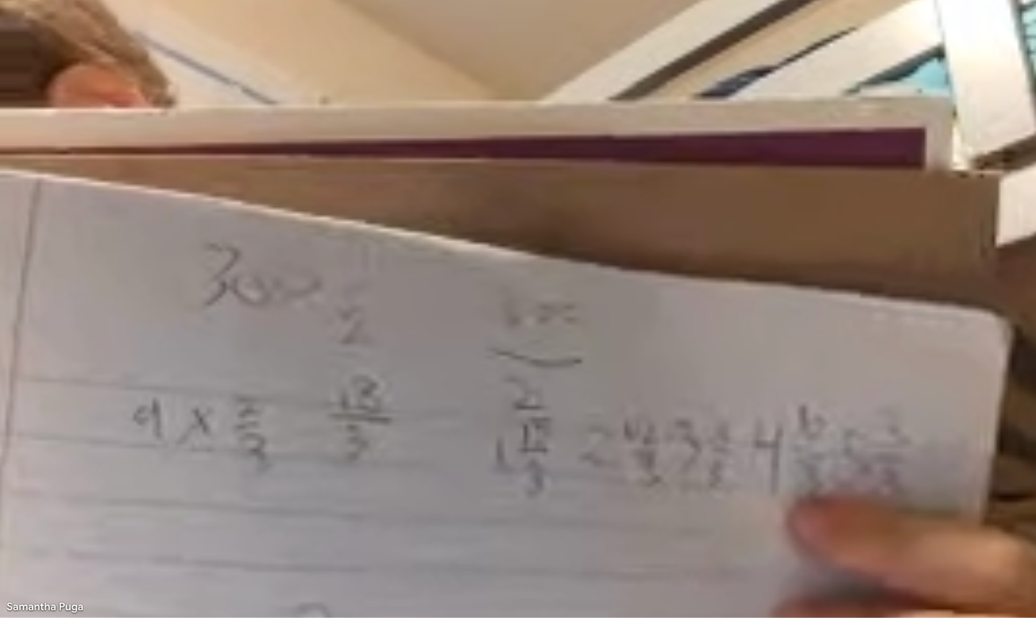 An image of the child I'm tutoring holding up a notebook with mathematical scribbles.