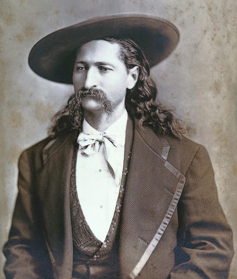 A man with a long, prominent nose and mustache wearing a hat, jacket and waistcoat.