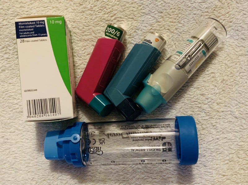 An assortment of asthma medication, inhalers and spacer.