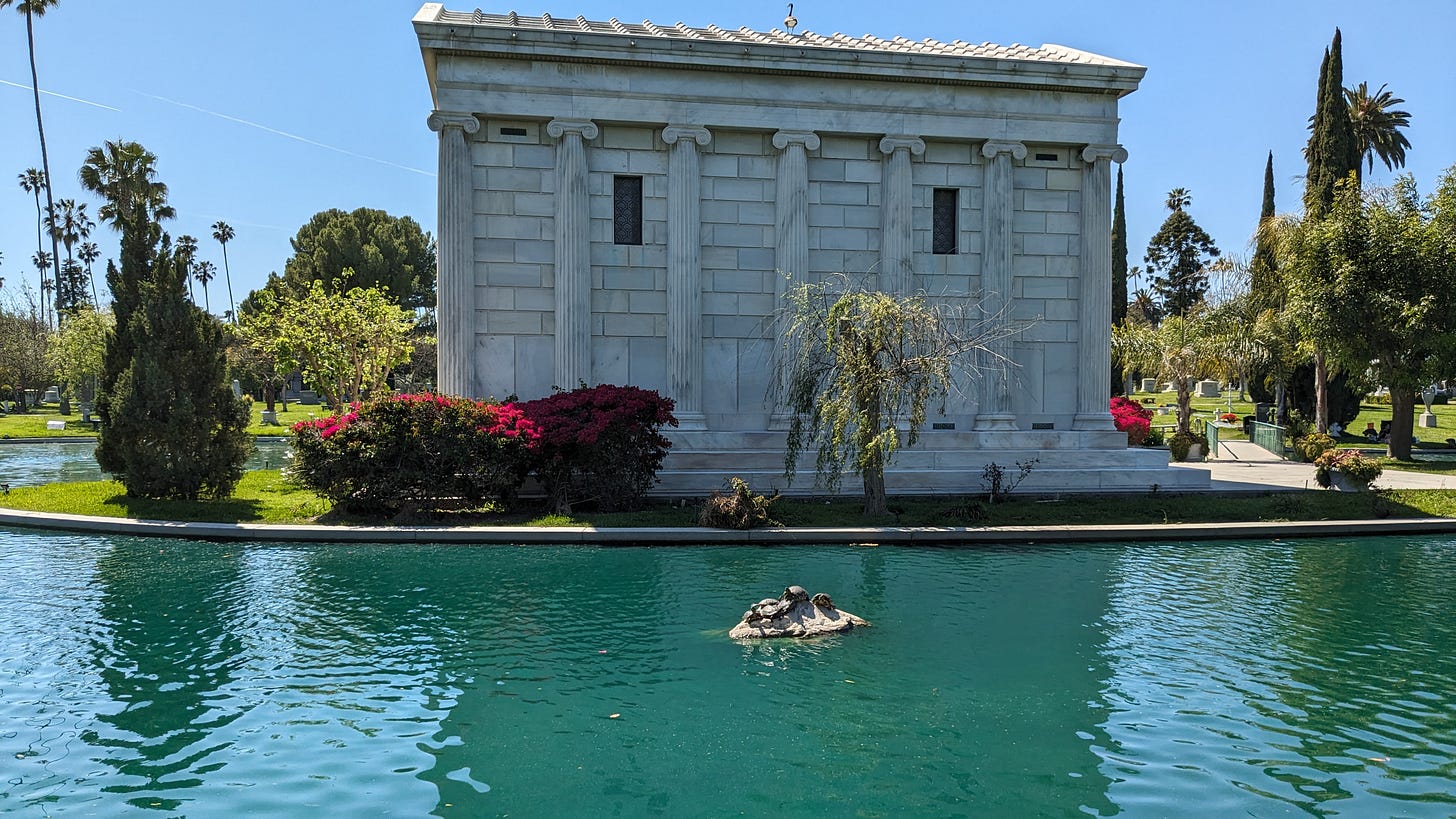 Turtles perch on a rock in the Sylvan Lake in front of the Clark mausoleum