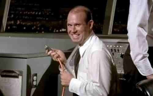 air traffic controller smiling while he pulls a plug off in airport control tower