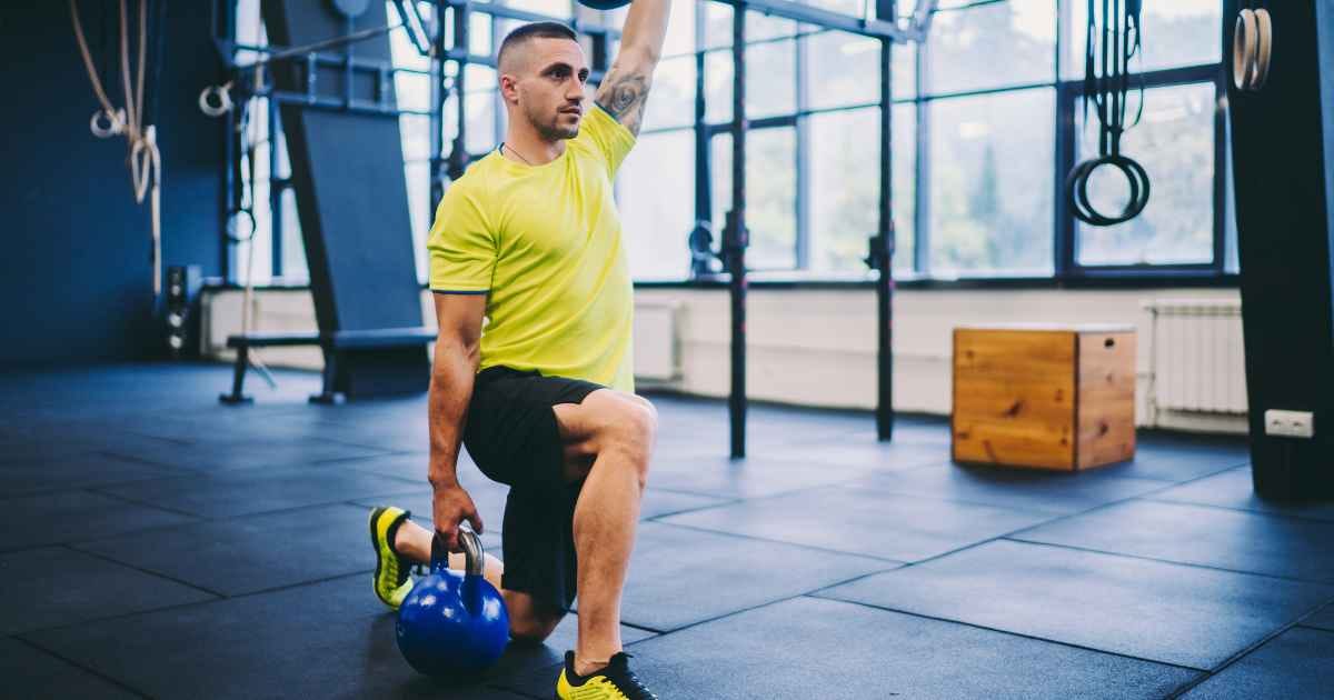 man doing kettlebell walking lunges