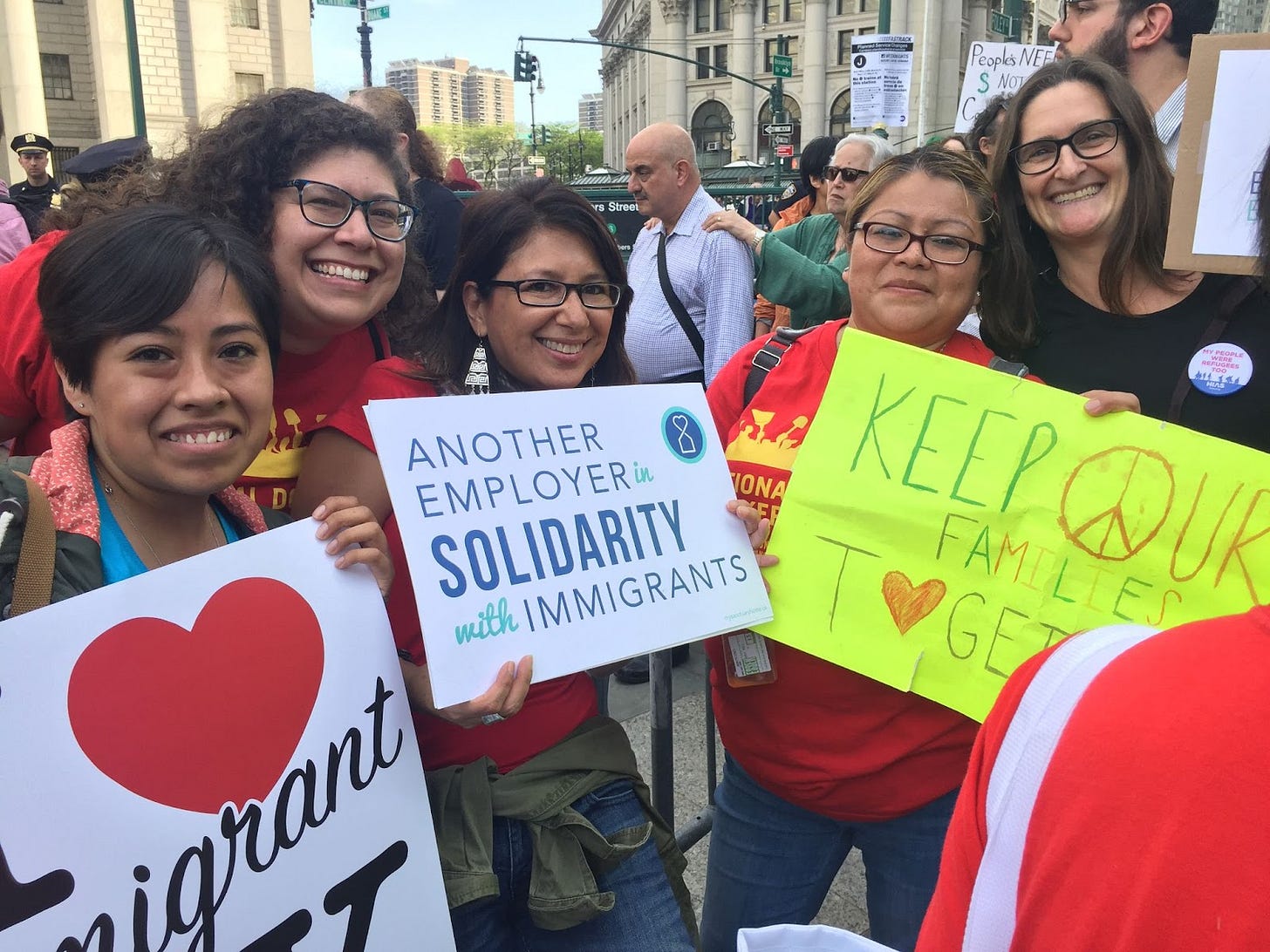 5 women holding signs together at a domestic worker rally. Brown and white skin women. 5 women holding signs together at a domestic worker rally. Brown and white skin women.