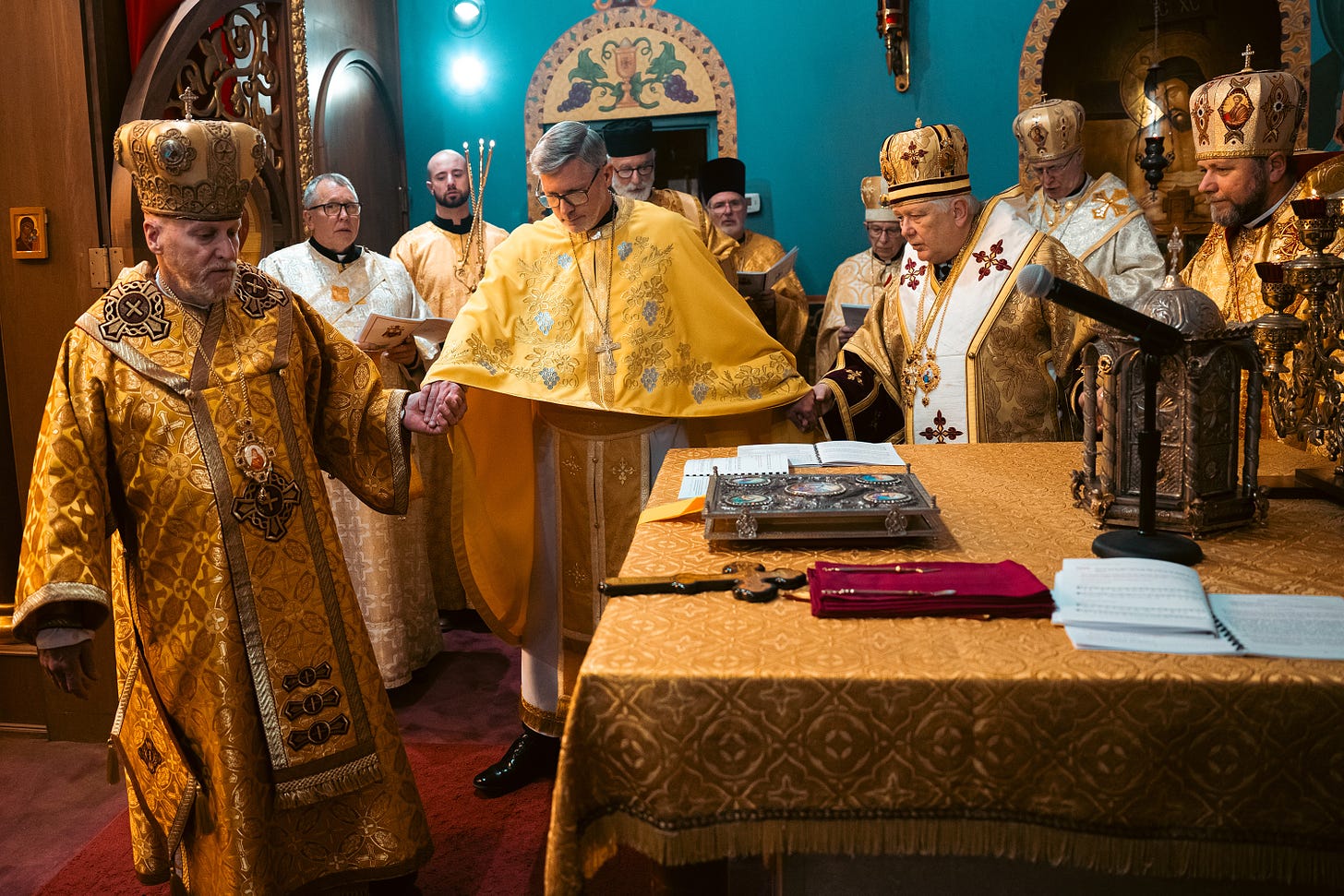 Father Robert Pipta is led around the altar three times by his three consecrators.