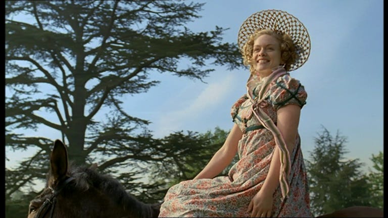 Woman in 18th-century dress is smiling while riding a donkey. Woman in 18th-century dress is smiling while riding a donkey.