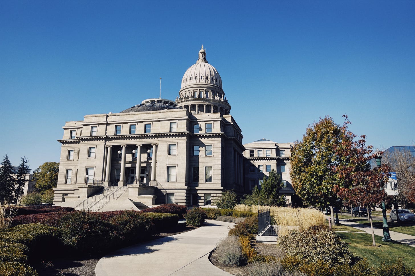 A photograph of the Idaho State Capitol building in Boise, pictured on a very sunny autumn day with a beautiful blue sky, and quite literally, not a cloud in sight.