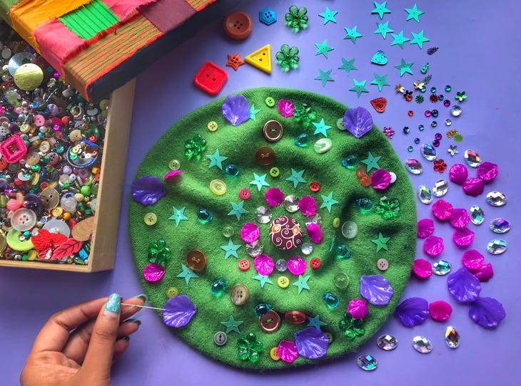 Various sequins, beads and craft materials spread over a table