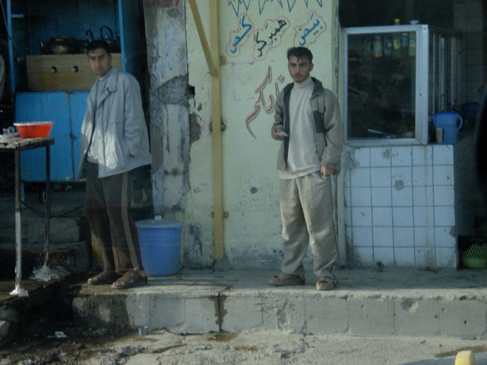 A couple of men standing outside a building

Description automatically generated