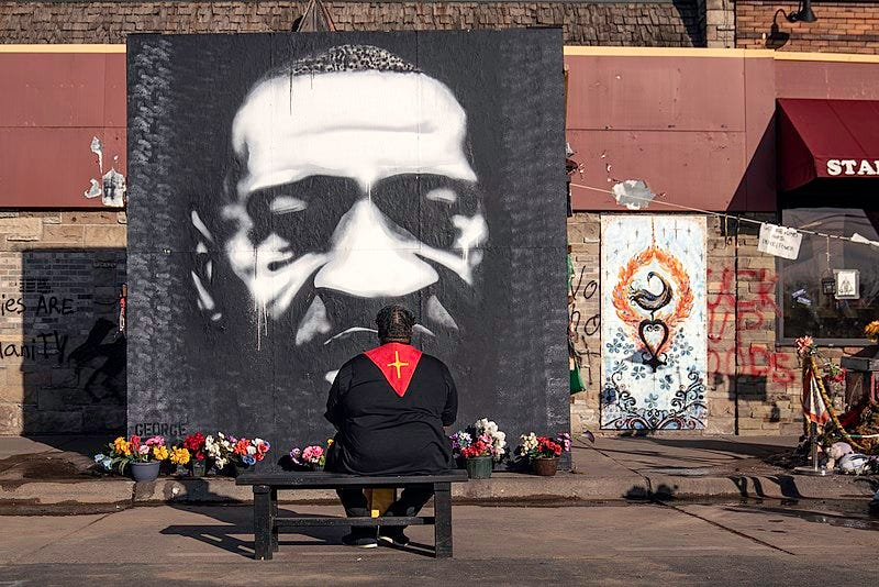 File:A pastor sits in front of a portrait of George Floyd by Peyton Scott Russell at East 38th Street and Chicago Avenue in Minneapolis on the weekend before Derek Chauvin's trial is scheduled to begin (51012488982).jpg