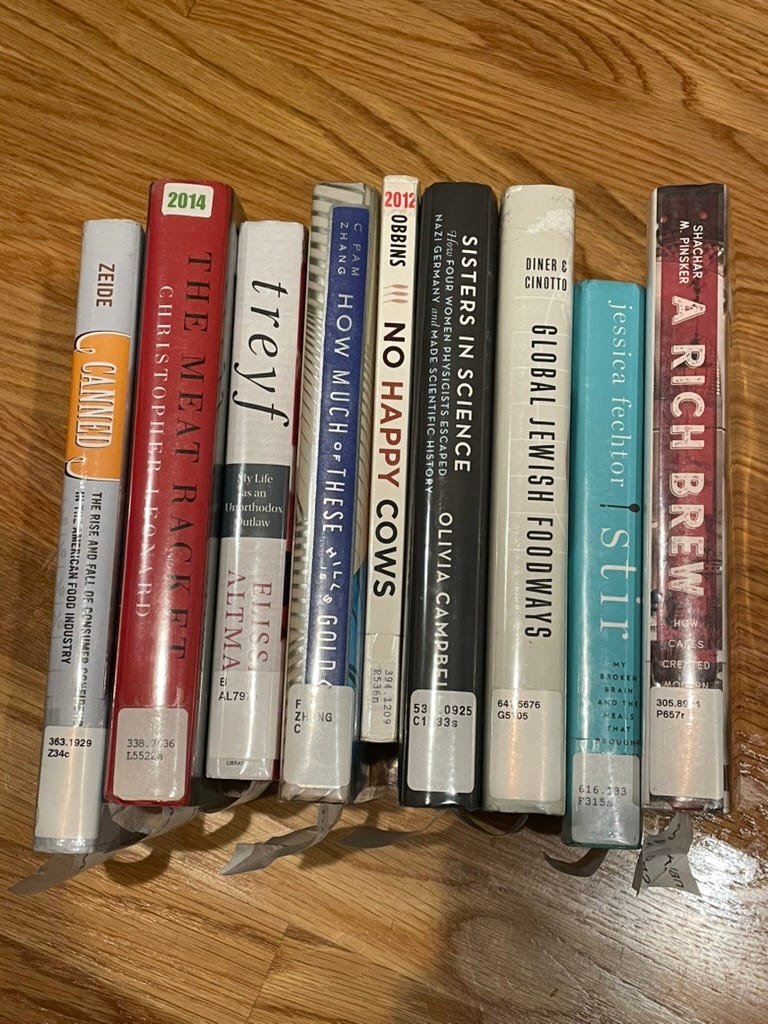 spines of books stacked together on top of a wooden table